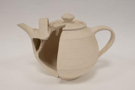 Clay teapot with a quarter cut out to see inside