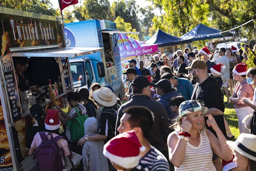 Crowd of people lining up for food at various food trucks