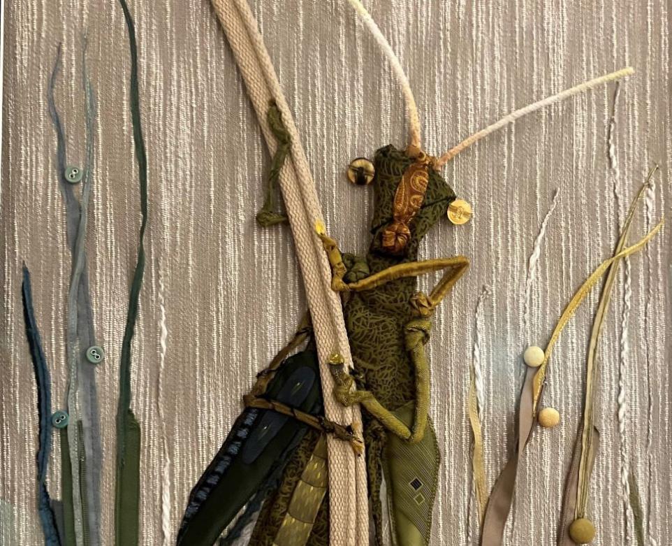 Artist rendering of a grasshopper in fabric and thread