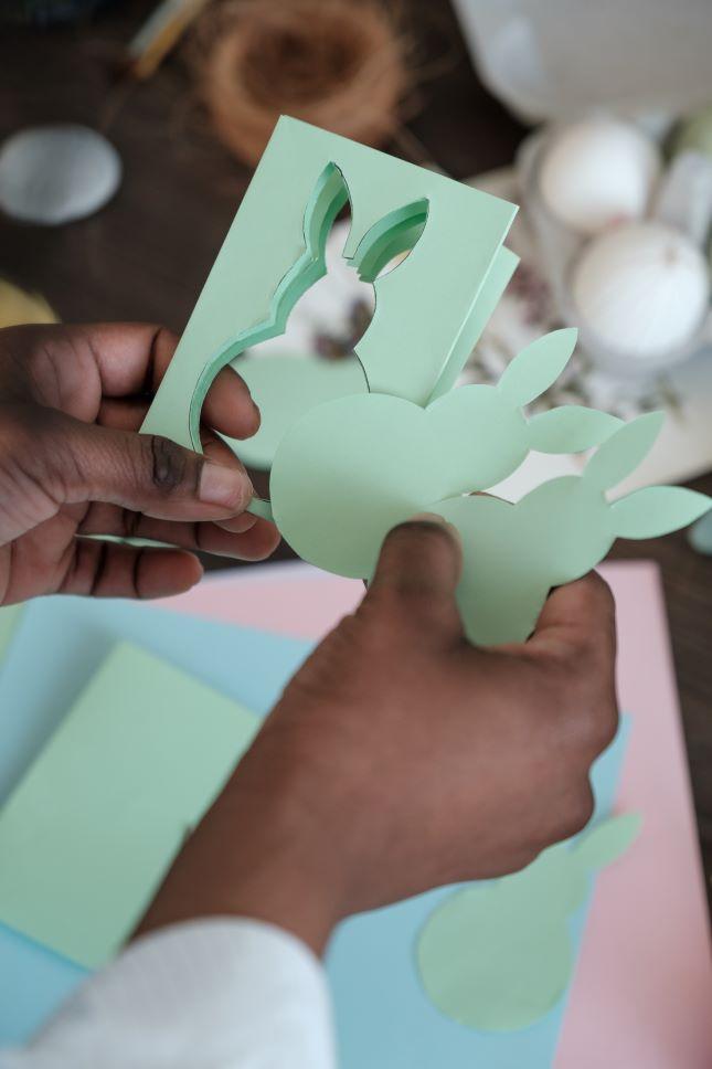 hands creating a paper bunny
