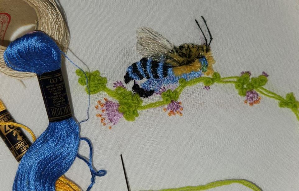 Embroidery showing a stitched bee 