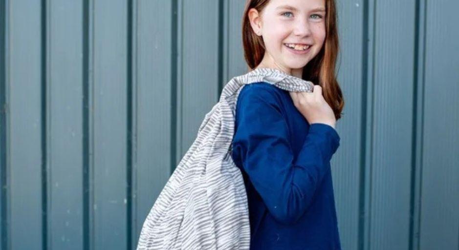 Young child holding  a bag over shoulder 