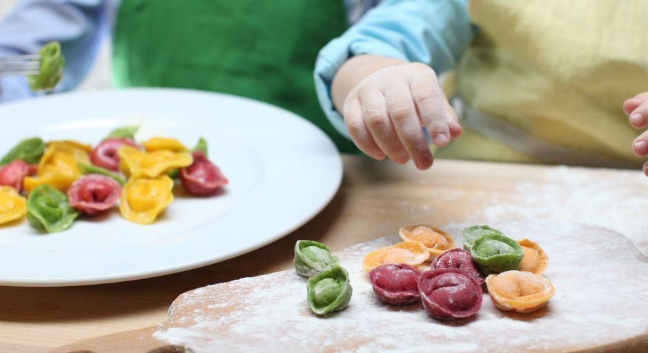 child cooking rainbow pasta 