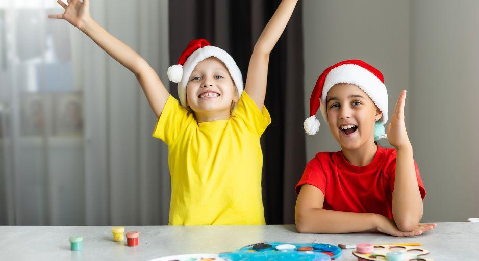Children wearing Christmas hats making crafts