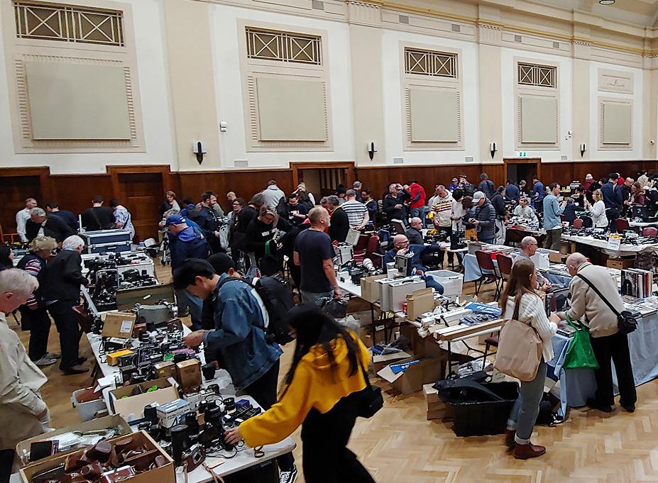 View looking over people examining market stalls in a hall.