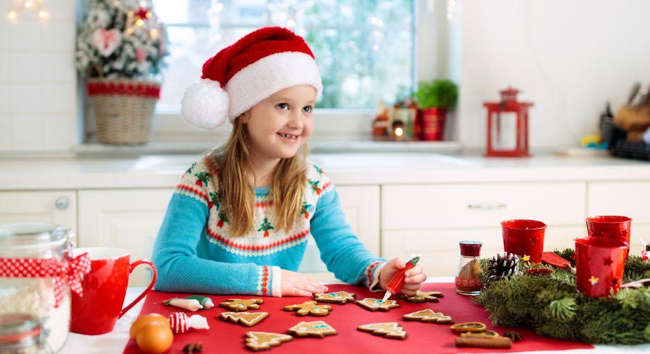 Child with Christmas hat on making Christmas Cookies 