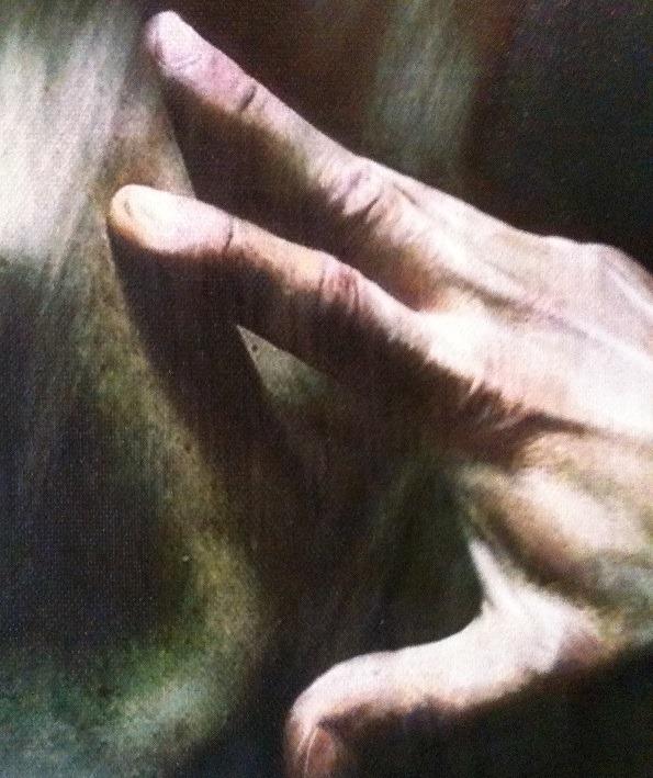 Close up image of a hand pressed onto a brown canvas