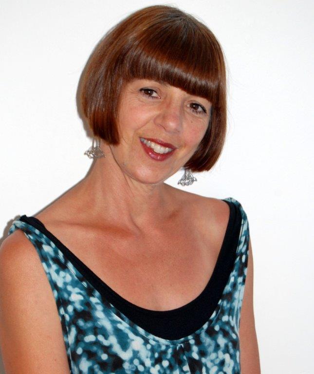 A lady with short brown hair in a blur singlet smiling at the camera