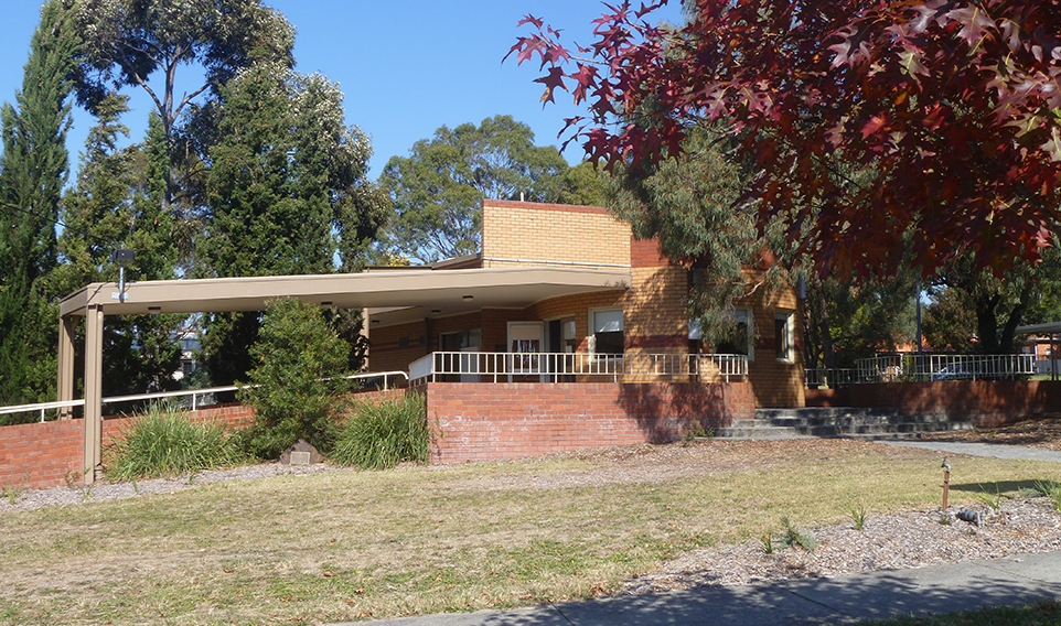 An external photo of the Strabane Hall. The sky is blue and the leaves are changing to red