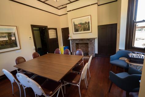 A room with a square table with chairs in the centre