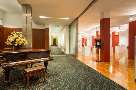 piano on left and exhibition space on right of The All Nations foyer