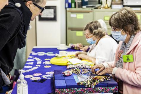 Women seated at a table making lace.