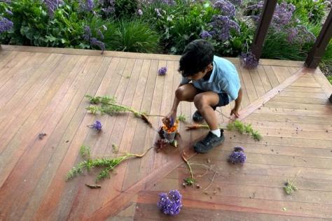 Child creating a mandala out of natural materials 