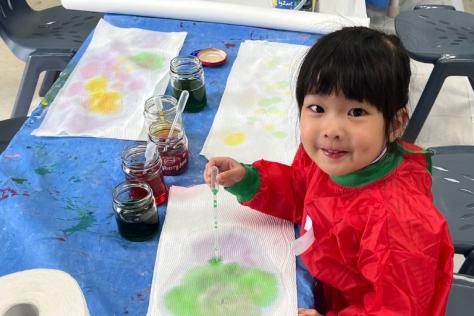 Young child playing with messy play arts materials