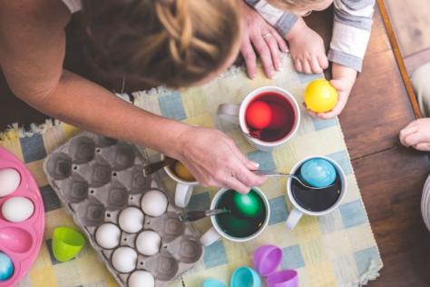 Person colouring easter eggs with food dye