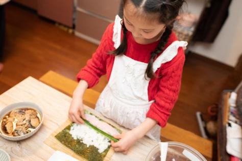 child making sushi hand rolls 