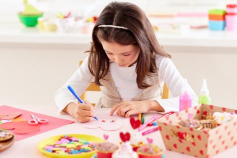 child in craft workshop making pop up cards 