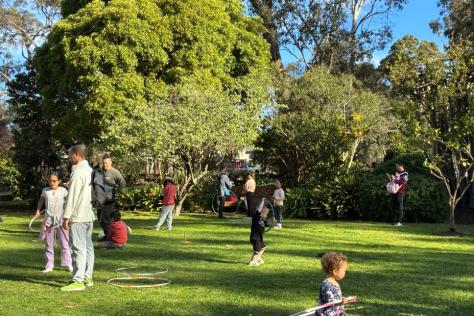 Children in a garden playing with hula hoops