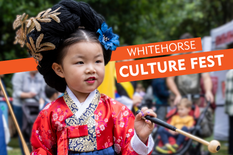 Young girl in traditional Korean clothing holding drum sticks