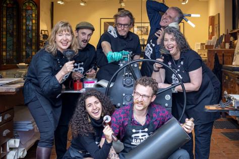 Group of people posing for the camera with printmaking equipment