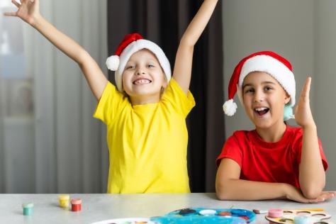 Children wearing Christmas hats making crafts