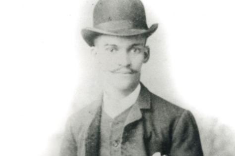 Black and white portrait of a man in a bowler hat.