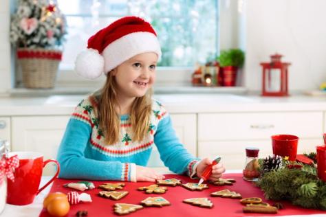 Child with Christmas hat on making Christmas Cookies 
