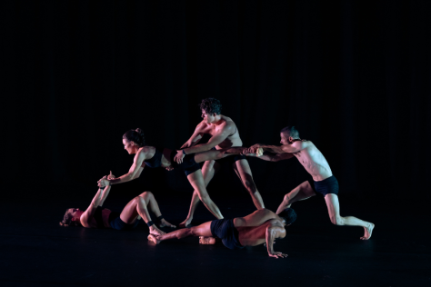 Five circus performers against a dark background