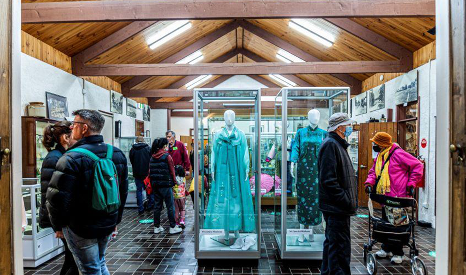 View of visitors to Schwerkolt Museum looking at items on display.