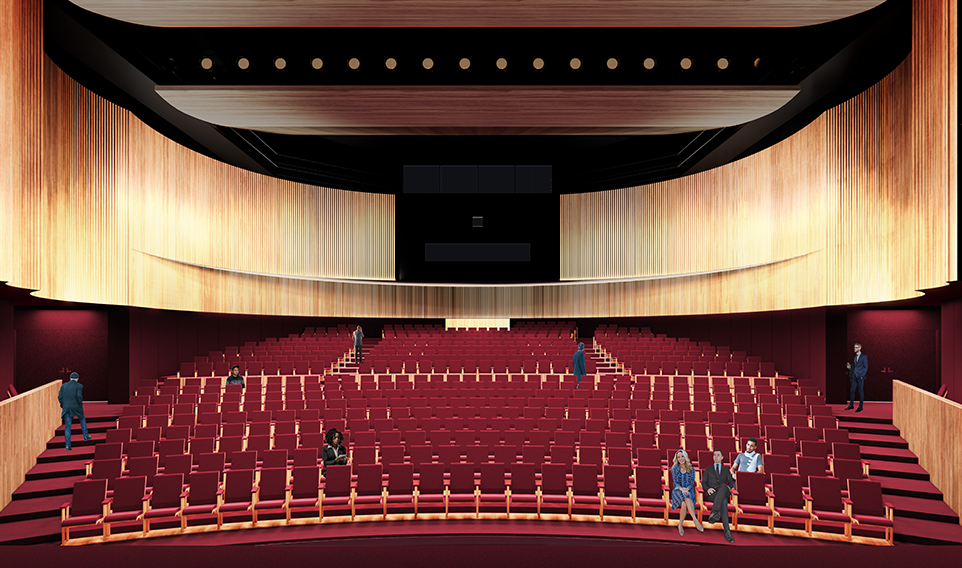 Large theatre space with red chairs and light wooden walls
