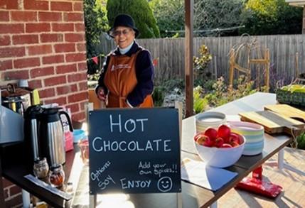 A volunteer helping to serve hot chocolate